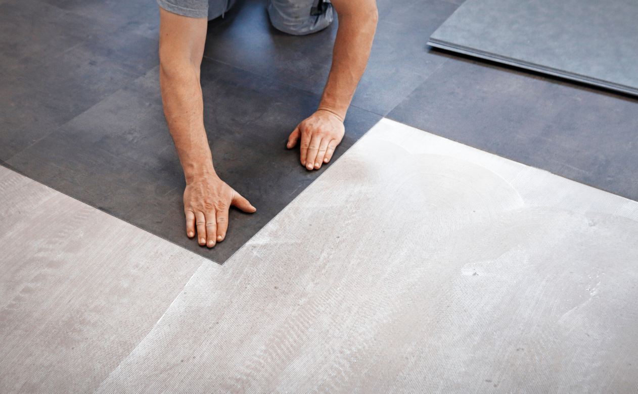 Close-up of luxury vinyl flooring installation, showcasing durability and precision. Learn what to know before buying vinyl at Carpet Master Carpet One's blog.