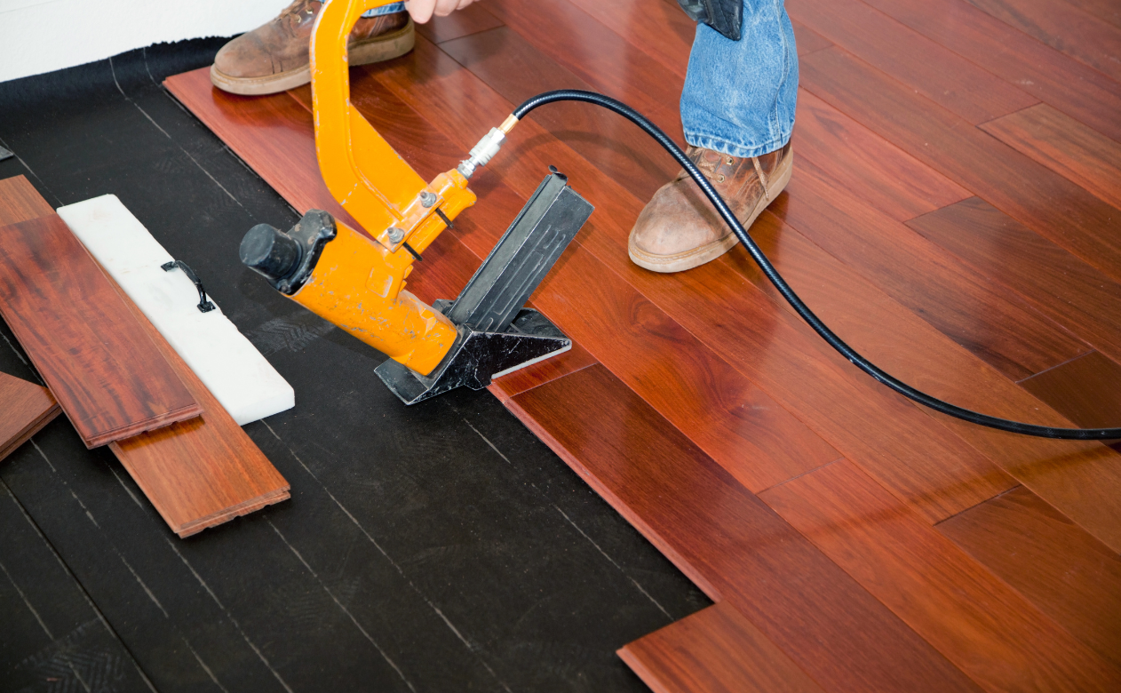 Installation of solid hardwood flooring, highlighting the craftsmanship and durability. Learn the difference between engineered and solid hardwood on Carpet Master Carpet One's blog.