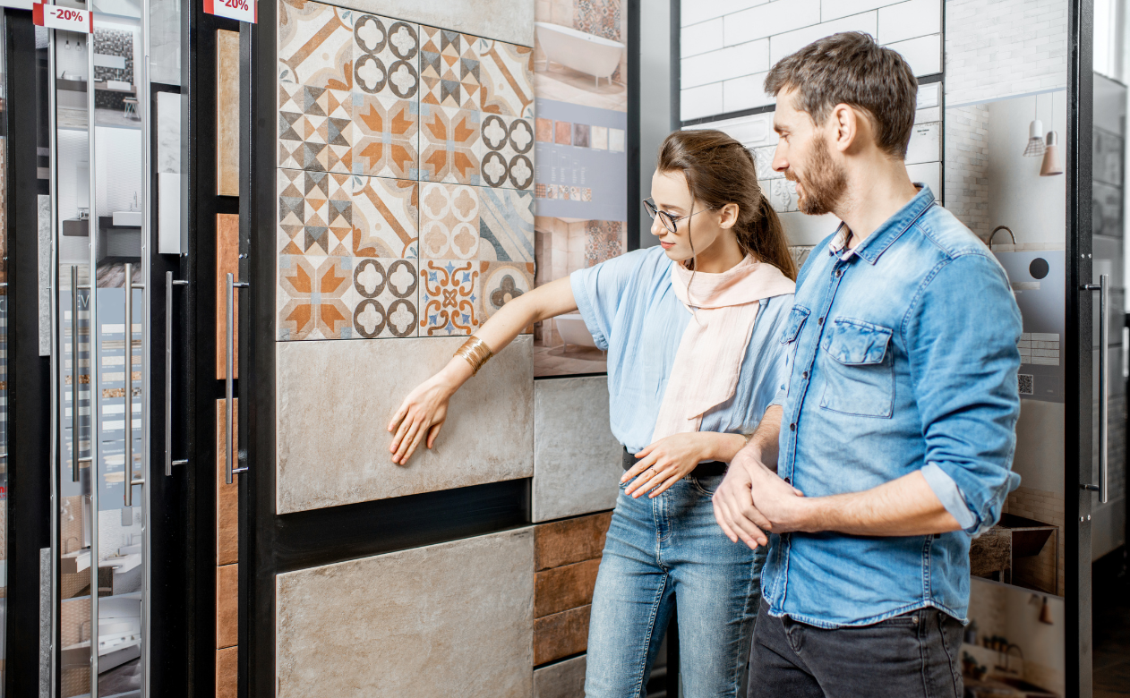 Customers examining decorative tile designs, showcasing the timeless appeal of tiles. Discover the rich history of tile at Carpet Master Carpet One's design blog.