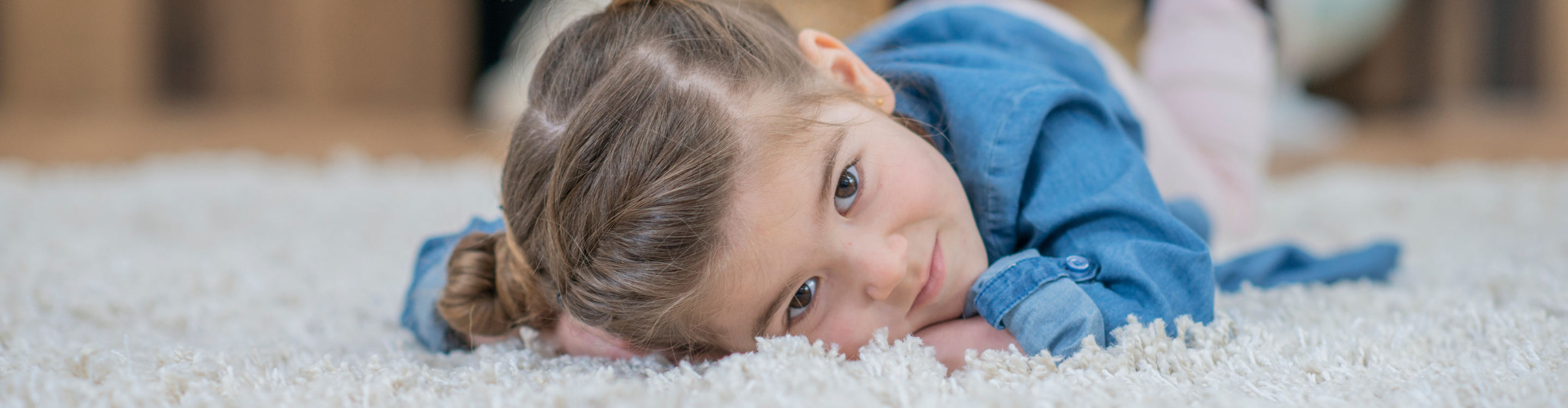 Child resting on soft and cozy carpet, perfect for family-friendly spaces. Explore the ultimate carpet guide at Carpet Master Carpet One for expert tips and inspiration.